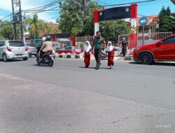Peduli Keselamatan Babinsa Koramil 1405-01/Ujung Bantu Anak – anak Sekolah Menyebrang Jalan